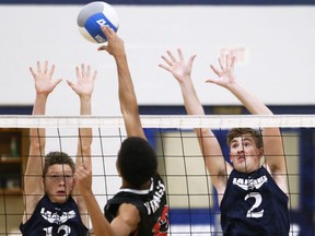 Ursuline Lancers' Rees Evans (13) and Tyler Canniff (2) try for a block against the Northern Vikings during an LKSSAA senior boys' volleyball AAA semifinal at Ursuline College Chatham in Chatham, Ont., on Tuesday, Nov. 8, 2022. Mark Malone/Chatham Daily News/Postmedia Network