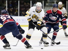 Sarnia Sting's Ethan Ritchie (74) tries to get past Saginaw Spirit's Dean Loukus (12) and Roberto Mancini (53) in the first period at Progressive Auto Sales Arena in Sarnia, Ont., on Friday, Nov. 11, 2022. Mark Malone/Chatham Daily News/Postmedia Network