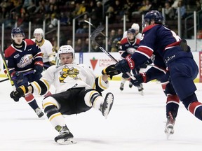 Sarnia Sting's Max Namestnikov, left, is knocked down by Saginaw Spirit's Brayden Hislop in the first period at the Progressive Auto Sales Arena in Sarnia, Ont., Friday, Nov. 11, 2022. Mark Malone/Chatham Daily News/Postmedia Network