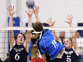 Ursuline Lancers' Alex Chickowski (6) and Ethan VanDerMeersch (5) try to block Sandwich Sabres' Travis Loughead (15) during the SWOSSAA senior boys' volleyball AAA championship at Ursuline College Chatham in Chatham, Ont., on Thursday, Nov. 17, 2022. Mark Malone/Chatham Daily News/Postmedia Network
