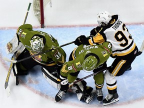 Avery Winslow of the North Bay Battalion and Patrick Thomas of the Hamilton Bulldogs battle beside North Bay goaltender Charlie Robertson, who gets a pad on the puck, in Ontario Hockey League action Friday night. The Troops opened a two-game road trip that continues Saturday night against the Erie Otters.