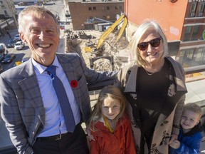 Steve Cordes, executive director of Youth Opportunities Unlimited, and Lynne Cram, daughter of Joan Smith, stand atop the YOU building at Richmond and York streets on Monday, Nov. 7, 2022 with the demolition continuing at the future site of Joan's Place across the road. Cram is with her grandchildren Amy Joan Elligsen, 6, and Evan Elligsen, 3. (Mike Hensen/The London Free Press)