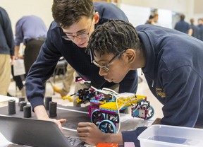 Regina Mundi High School students Nathan DeLellis, 14, and Tyrese Nganga, 14, study the software they wrote to control their robot. (Mike Hensen / Postmedia Network)