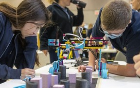 Liam Kilpatrick, 14, and Ricker Gregory, 14, of St. Joseph's High School in St. Thomas, study their robotic team, designed for various harvesters 
