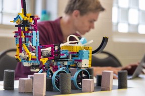 Colin Ten Hoff, 16, a Year 11 student at Rehoboth Christian School in Norwich, works on his computer program while a school team robot waits between