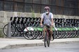 A cyclist wearing a mask rides past a row of Bike Share Toronto rental bikes during the COVID-19 pandemic on July 27, 2020.