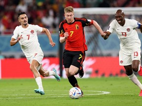 Kevin De Bruyne of Belgium attempts to move away from Stephen Eustaquio of Canada and Atiba Hutchinson of Canada during the FIFA World Cup Qatar 2022 Group F match between Belgium and Canada at Ahmad Bin Ali Stadium on November 23, 2022 in Doha, Qatar.