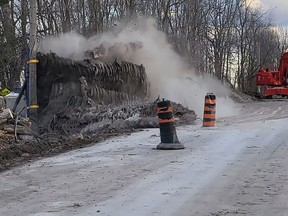 Crews detonate explosives beneath tons of recycled tires attached to metal grates on Beach Road in Tyendinaga Mohawk Territory on Thursday. The crew, from Gordon Barr Ltd., worked meticulously to place the weights on top of the explosives, which were used to blast rock so crews can lay piping in the coming weeks as part of the most recent phase of the watermain distribution project. (Jan Murphy/Local Journalism Initiative)