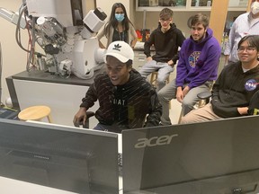 Joshua Coar, of Assumption College, works on monitors at the at the Canadian Centre for Electron Microscopy at McMaster University while classmates Nicholas Martino, Cohan Grieve and Dante Castro watch. Vincent Ball