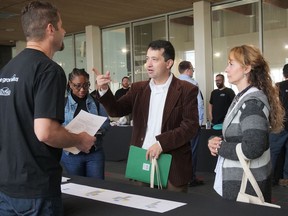 Kris Olson, from the City of Brantford's Information Technology department, on the left, spoke to Amaka Nwabulue, Cesar Mesa and Gloria Gutierrez Saturday at the City of Brantford's Come Grow With Us job fair at the Wayne Gretzky Sports Centre. Approximately 270 job seekers attended the event. CHRIS ABBOTT