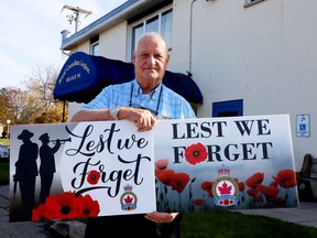 Royal Canadian Legion Branch 96 President Ralph McMullen poses with the two versions of the Remembrance Day lawn signs the branch is selling as a fundraiser. (RONALD ZAJAC/The Recorder and Times)