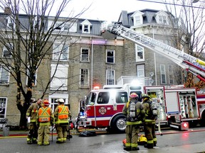 Firefighters confer at the scene of a fire at a Church Street apartment building on Saturday morning. (RONALD ZAJAC/The Recorder and Times)