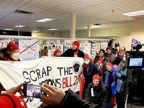 Protesters with the Association of Community Organizations for Reform Now (ACORN) pose for a group photo after placing their posters inside Municipal Affairs Minister Steve Clark's Brockville constituency office on Friday morning. (RONALD ZAJAC/The Recorder and Times)