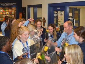 Head coach Matt Reil hands out yellow roses to the golden girls of St. Mary Catholic High School before the hallway parade in honour of the Ontario basketball champions on Monday, Nov. 28.
Tim Ruhnke/The Recorder and Times