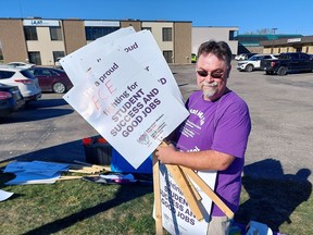Canadian Union of Public Employees member Dan Ryan, an education assistant at Tecumseh Public School in Chatham, holds a number of placards that will be kept nearby if the union representing 55,000 education support workers believes the Ford government isn't bargaining in good faith after reaching a deal to end a two-day strike on Monday. (Ellwood Shreve/Chatham Daily News)