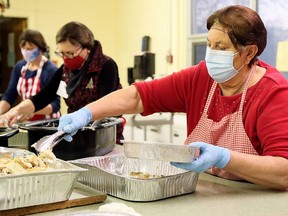 Grace Magliaro, right, Jane Butterman and Jan Brosseau package meals during Interfaith Caring Kitchen's annual Christmas dinner held in 2020 at the Spirit & Life Centre in Chatham. This year's event, being held Dec. 7, will return to a sit-down meal for the first time since 2019. File Photo Mark Malone/Chatham Daily News
