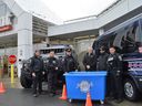 Cornwall Police Services (CPS) officers standing with owner John Baxtrom of Your Independent Grocer during the Putting the Cuffs On Hunger event on Friday November 18, 2022 in Cornwall, Ont.  Shawna O'Neill/Cornwall Standard-Freeholder/Postmedia Network