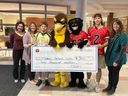 From left at a Charity Bowl presentation of funds to the Children's Treatment Centre are Celine Langevin (Holy Trinity vice principal), Nancy McIntyre (Holy Trinity principal), Ben Kisnics (representing Holy Trinity football), the Falcons mascot, the Panthers mascot, Colby Delves (representing St. Joseph's football), and Joy Martel (St. Joseph's principal). Photo on Monday, November 21, 2022, in Cornwall, Ont. Todd Hambleton/Cornwall Standard-Freeholder/Postmedia Network