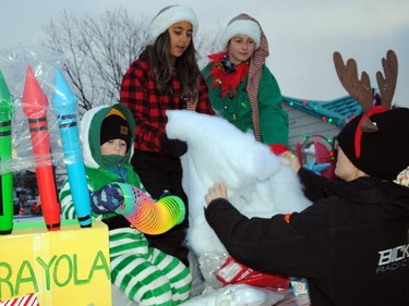Left, Oskar Cholock waits for Macey Poirier, Myleigh MacDonald, and Hannah Thompson to finish preparations for Ladouceur Mechanical's float before the start of the Santa Claus Parade on Saturday November 19, 2022 in Cornwall, Ont. Greg Peerenboom/Special to the Cornwall Standard-Freeholder/Postmedia Network