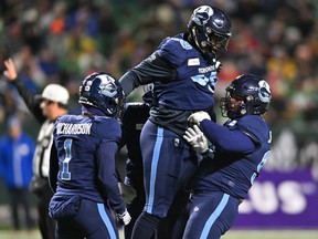 Toronto Argonauts defensive line Dewayne Hendrix (99) and Argos defensive back Shaq Richardson (1) celebrate on the field during the first quarter at the 109th Grey Cup at Mosaic Stadium in Regina on Sunday, Nov. 20, 2022.