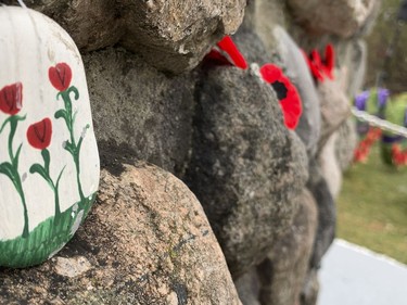 Poppies and kindness stones covered the cenotaph after the Matthew J Dawe Memorial Branch Remembrance Day cenotaph service in W. C Warnica Memorial Park in Kingston, Ont. on Friday, Nov. 11, 2022.