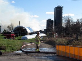 Kingston Fire and Rescue firefighters battle a barn fire at a property on Highway 2 east of Kingston on Monday.