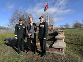 Maj.-Gen. Michael Wright, Peter Weeks, and Home Station Commander Lt.-Col. Andrew Duncan stand in front of the nearly completed monument built to commemorate Peter's father, Maj.-Gen. Reg Weeks, and the role he played in developing Canada's Intelligence Branch. A ceremony unveiled the monument at Canadian Forces Base Kingston on Saturday.