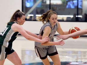 Frontenac Falcons' Jessie Dean Savage drives past Holy Cross Crusaders' Abby Sinclair in the Kingston Area Secondary Schools Athletic Association senior girls basketball final at St. Lawrence College on Monday. Frontenac won the game, 50-38.