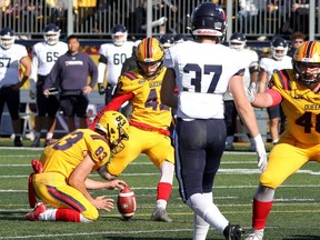 Queen's Gaels kicker Tyler Mullan kicks a successful field goal against the Toronto Varsity Blues in an Ontario University Athletics football quarter-final game on Saturday, Oct. 29, 2022. Holding the ball is Richard Burton and looking on is Blues Caleb Zigby. Queen's won the game, 41-13. Ian MacAlpine/The Kingston Whig-Standard/Postmedia Network
