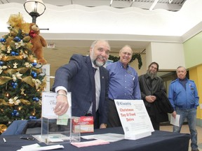 Pembroke Mayor Elect Ron Gervais made a donation to the Kiwanis Christmas Toy and Food Drive during the kick-off event at the Pembroke Mall Nov. 16 while Kiwanian Jay McLaren, drive co-chairman, Chris McArton (the toy guy), and Kiwanian Mack Thrasher, drive co-chairman look on. Anthony Dixon