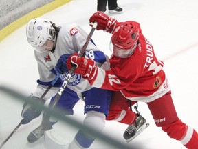 Sacha Trudel of the Pembroke Lumber Kings pins Lucas DiChiara against the boards as they both battle for the puck in first period action Nov. 20 at the PMC. Anthony Dixon