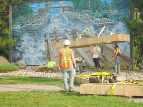 Walsh Brothers Constructions works to install bew timbers for part of the 3-dimensional portion of The Timber Raft Mural. Pembroke Heritage Murals photo