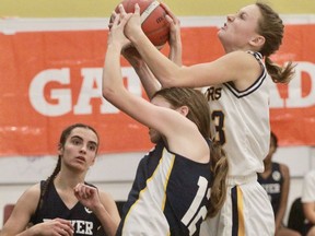 St. Mike's Jensen Pohl fights for a rebound against Monsignor Paul Dwyer during the OFSAA girls' basketball opener Thursday at SDSS.