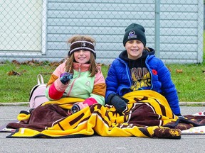 LOYAL FANS Cousins Mia Annett and Angela Thomson found their cozy spot on the track at the Superior Heights football field Saturday afternoon where the Korah Colts defended their NOSSA championship title against the Algonquin Barons. Mia and Angela were rooting for the Colts and of course Mia's father, Korah Colts coach Tom Annett. BOB DAVIES