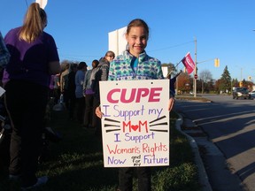 Kensley Davis, 7, daughter of an educational assistant, takes part in a rally Tuesday evening outside the Point Edward office of Sarnia-Lambton MPP Bob Bailey.