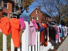 Hand-kitted hats, scarves and mittens hang on the fence at the Lawrence House in Sarnia during last year's Scarf Day organized by the group 100 Scarves. Anyone needing the items was invited to take them and the rest were being donated to local shelters. This year's event is Friday, 10 a.m. to 4 p.m., at the centre.