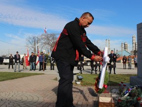 Veteran Brian Bois pins a poppy during Thursday's Remembrance Day service at the Aamjiwnaang First Nation in Sarnia.