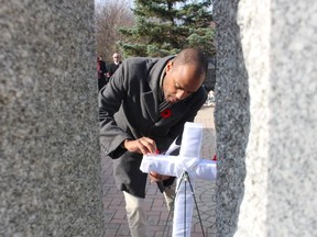 Rev.  Adam Kilner pins a poppy during Thursday's Remembrance Day service at the Aamjiwnaang First Nation in Sarnia.