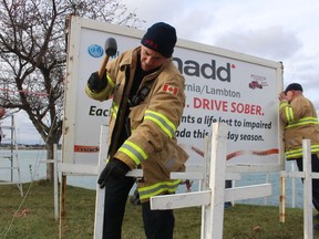 Sarnia firefighter Dennis Fillion helps set up the MADD Sarnia-Lambton white cross display Saturday on the St. Clair Parkway.  The annual holiday-season display illustrates the impact of impaired driving.