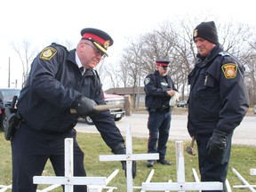 Sarnia Police Chief Derek Davis, left, and Fire Chief Bryan Van Gaver help set up the MADD Sarnia-Lambton white cross display Saturday on the St. Clair Parkway.  The annual holiday-season display illustrates the impact of impaired driving.