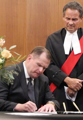 count.  Bill Dennis signs the oath of office at the 2022-2026 Sarnia city council inaugural meeting Nov. 15, 2022.Justice Paul Kowalyshyn looks on.  (Tyler Kula/ The Observer)