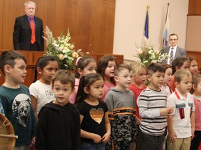 Sarnia Mayor Mike Bradley and Coun.  Dave Boushy listen as Aamjiwnaang Binoojiinyag Kino Maagewgamgoons Early Learning Center kindergarteners sing the national anthem in Sarnia city council chambers.  (Tyler Kula/ The Observer)