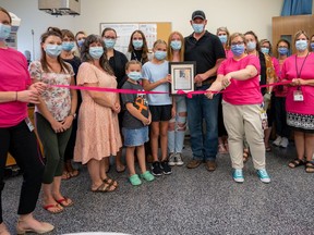 Dr. Jamie Szabo, chief of obstetrics (front right, with scissors), cuts the ribbon to celebrate the reopening of the labor and delivery unit at Norfolk General Hospital.  Szabo is joined by members of the labor and delivery unit team, midwives, and special guests, Brad, Abby, and Emma Adams.  CONTRIBUTED