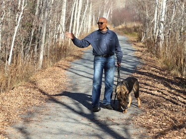 Tom Abraham, of BlackTracks K9, uses his dog to search an area at Rotary Park Trail in Sudbury, Ont. on Tuesday November 1, 2022. The company was brought to Sudbury by the organization, Please Bring Me Home, to search for Meagan Pilon, last seen on Sept. 11, 2013. John Lappa/Sudbury Star/Postmedia Network