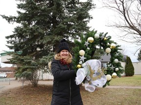 Volunteer Brigitte Labby, of Cafe Heritage, displays a wreath that was purchased for the Tree of Hope initiative in Azilda, Ont. on Wednesday November 30, 2022. A ceremony will be held at the tree located in front of the former Caisse Populaire on Dec. 1 at 7 p.m., where a tree-lighting ceremony will take place and "We will recite each person's name," said a release issued by Cafe Heritage. The tree is adorned with more than 100 memorial lights, and seven wreaths were purchased as a result of generous community donations by individuals, families and corporations, purchased in memory of loved ones. The Tree of Hope received support from CAN Azilda and many other community volunteers. The tree will remain illuminated until January 1, 2023. John Lappa/Sudbury Star/Postmedia Network