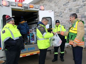 Allan Rennie, Cochrane District EMS paramedic, from left, Jean Carrière, director and chief of EMS, Derrick Cremin, EMS commander, and Daniel Rochon, lieutenant with the Timmins Fire Department, at the Fill-an-Ambulance toy drive on Saturday. Rochon is seen donating miniature fire trucks outside of the Canadian Tire on Riverside Drive. The toy drive provides gifts to hundreds of children who receive support from the North Eastern Ontario Family and Children's Services. 

NICOLE STOFFMAN/The Daily Press