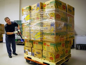 Christmas Care volunteer Rob Johnstone wheels in banana boxes to be filled with groceries and toys in this year's campaign, which begins registration Monday at Memorial auditorium. Organizers are expecting an increase in need. (Eric Bunnell/Special to Postmedia Network)