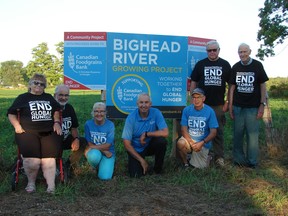 Members of the Bighead River Foodgrains growing project pose in front of a sign at the Reinders' farm on County Road 12  at Sideroad 25 in the Municipality of Grey Highlands. From left to right, Norma McCauley, John Howard, Brenda Rogers, Henry Reinders, Wes Sparling. Ray Mills and Garry Aitken.  Missing from the picture are Truus Dales, Muriel Lush and Rev. Anne-Marie Jones. Photo supplied.