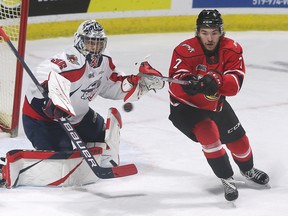 Brankár Windsor Spitfire Mathias Onuszka a Deni Goure z Owen Sound Attack sledujú v stredu 23. novembra 2022 odraz puku v centre WFCU vo Windsore. (Windsor Star - DAN JANISSE)
