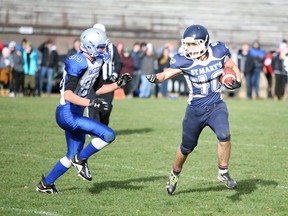 Matt Molinski tries to keep tackler Austin Dunlop at arm's length while running in the ball in the first quarter of the Bluewater Athletic Association football championship between the St. Mary's Mustangs and Saugeen District Royals Monday at Victoria Park. The Mustangs won their eighth-straight BAA title 41-7. Greg Cowan/The Sun Times